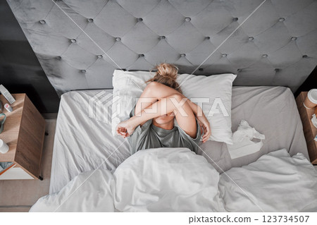 Tired, sad and sick woman in bed with insomnia in the bedroom of house from above. Top view of girl with depression, anxiety and mental health problem thinking of sleep, stress and burnout in home Tired, sad and sick woman in bed with insomnia in the bedroom of house from above. Top view of girl with depression, anxiety and mental health problem thinking of sleep, stress and burnout in home 123734507
