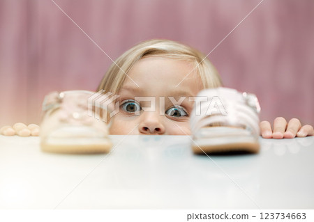 Girl, shoes and shopping with a child customer deciding between footwear for fashion, style or consumerism. Children, retail and option with a kid looking at a sandle and comparing for her wardrobe 123734663