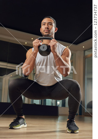 Workout, squat and kettlebell with man in gym for exercise, muscle and health. Fitness class, weights and sports center with male person training in studio for wellness, athlete and challenge 123734737
