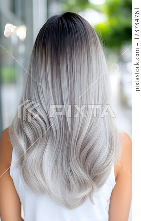 Elegant long gray ombre hairstyle with soft waves showcased outdoors in bright natural light during day time 123734761