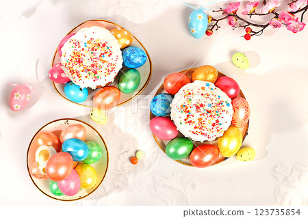 Abstract Easter composition with traditional Russian kulich with meringue and decorated eggs on elegant kitchen table with spring sakura flowers. Happy Easter concept. Abstract Easter composition with traditional Russian kulich with meringue and decorated eggs on elegant kitchen table with spring sakura flowers. Happy Easter concept. 123735854