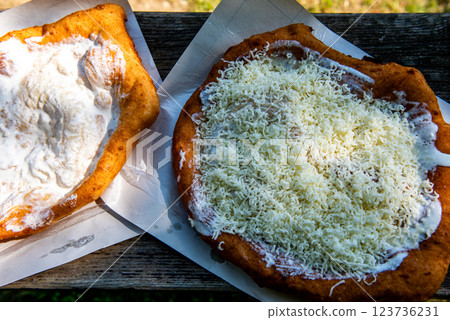 sour cream langos, streetfood. Typical homemade Hungarian food called Langos sour cream langos, streetfood. Typical homemade Hungarian food called Langos 123736231