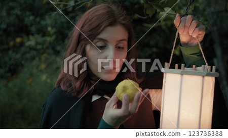 Woman Smells A Lemon Found In The Forest At Night With A Lantern Woman Smells A Lemon Found In The Forest At Night With A Lantern 123736388