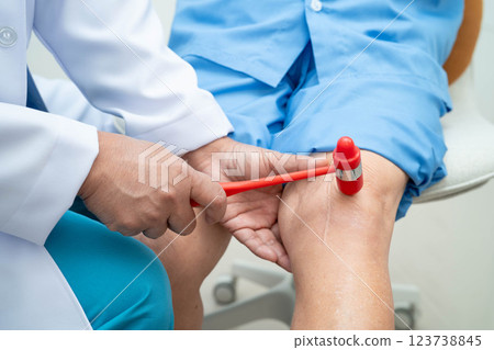 Asian doctor knock on knee reflex nerve for check and treatment senior patient in hospital. Asian doctor knock on knee reflex nerve for check and treatment senior patient in hospital. 123738845