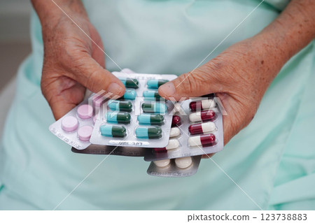 Asian elderly woman holding pill drug in hand, strong healthy medical. 123738883