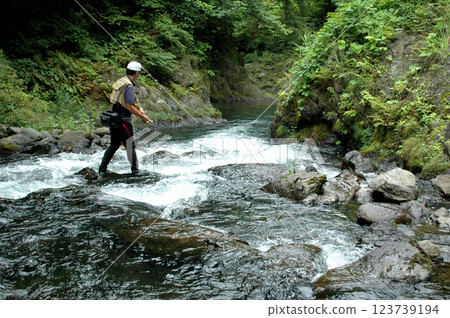 A man enjoying lure fishing in a steep mountain stream 123739194