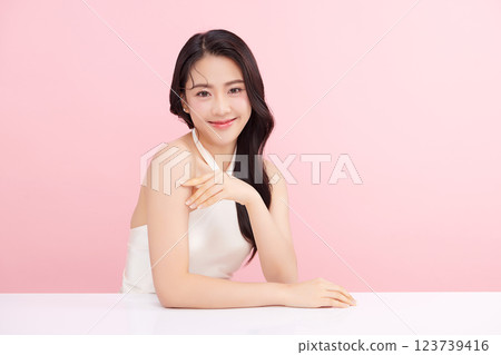 A beautiful young Asian woman with clean, fresh skin against a pink background. Skincare, facial treatment, cosmetology, beauty, and spa. An elegant portrait of an Asian woman. A beautiful young Asian woman with clean, fresh skin against a pink background. Skincare, facial treatment, cosmetology, beauty, and spa. An elegant portrait of an Asian woman. 123739416
