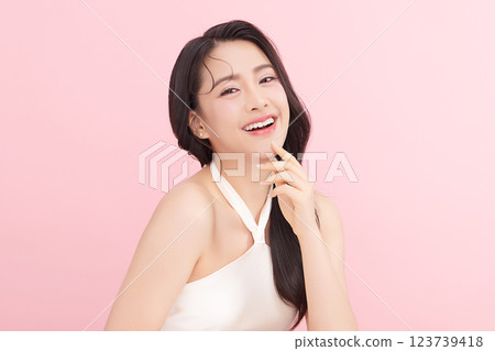 A beautiful young Asian woman with clean, fresh skin against a pink background. Skincare, facial treatment, cosmetology, beauty, and spa. An elegant portrait of an Asian woman. A beautiful young Asian woman with clean, fresh skin against a pink background. Skincare, facial treatment, cosmetology, beauty, and spa. An elegant portrait of an Asian woman. 123739418