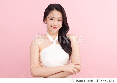 A beautiful young Asian woman with clean, fresh skin against a pink background. Skincare, facial treatment, cosmetology, beauty, and spa. An elegant portrait of an Asian woman. 123739423