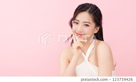 A beautiful young Asian woman with clean, fresh skin against a pink background. Skincare, facial treatment, cosmetology, beauty, and spa. An elegant portrait of an Asian woman. A beautiful young Asian woman with clean, fresh skin against a pink background. Skincare, facial treatment, cosmetology, beauty, and spa. An elegant portrait of an Asian woman. 123739426
