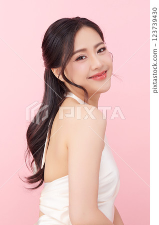 A beautiful young Asian woman with clean, fresh skin against a pink background. Skincare, facial treatment, cosmetology, beauty, and spa. An elegant portrait of an Asian woman. A beautiful young Asian woman with clean, fresh skin against a pink background. Skincare, facial treatment, cosmetology, beauty, and spa. An elegant portrait of an Asian woman. 123739430