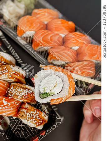 Japanese sushi rolls with salmon, avocado and cream cheese on black background, close-up.  123739598