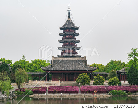 Traditional Chinese pagoda surrounded by vibrant flowers in a tranquil garden setting Traditional Chinese pagoda surrounded by vibrant flowers in a tranquil garden setting 123740139