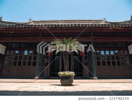 Palm tree in the courtyard of a traditional Chinese building under a clear blue sky Palm tree in the courtyard of a traditional Chinese building under a clear blue sky 123740254