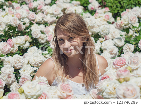Young woman enjoys a sunny day among blooming roses in a vibrant garden setting Young woman enjoys a sunny day among blooming roses in a vibrant garden setting 123740289