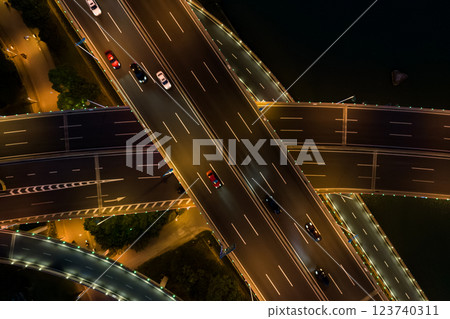 Aerial view of a busy road junction during nighttime with illuminated highways and moving vehicles. 123740311