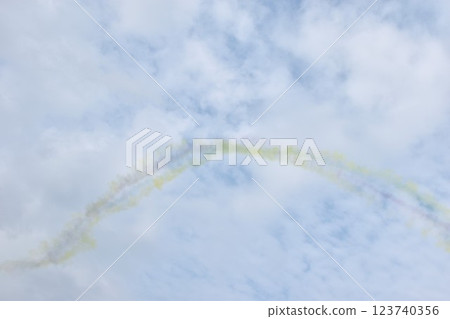 colorful vapor condensation trail from plane spreading in cloud on bright sky in sunny day 123740356