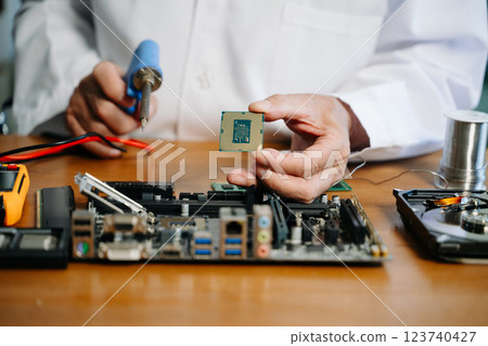 The technician is putting the CPU on the socket of the computer motherboard. electronic engineering electronic 123740427