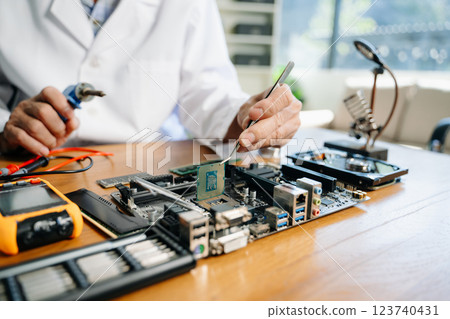 The technician is putting the CPU on the socket of the computer motherboard. electronic engineering electronic The technician is putting the CPU on the socket of the computer motherboard. electronic engineering electronic 123740431