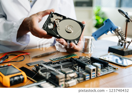 Technician repairing inside of hard disk drive by screwdriver. the concept of data, hardware, technician Technician repairing inside of hard disk drive by screwdriver. the concept of data, hardware, technician 123740432