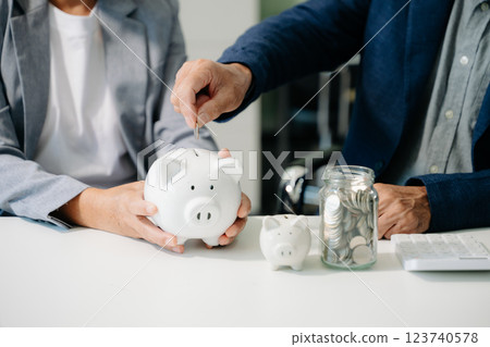 business team holding coins putting in glass with using smartphone and calculator business team holding coins putting in glass with using smartphone and calculator 123740578