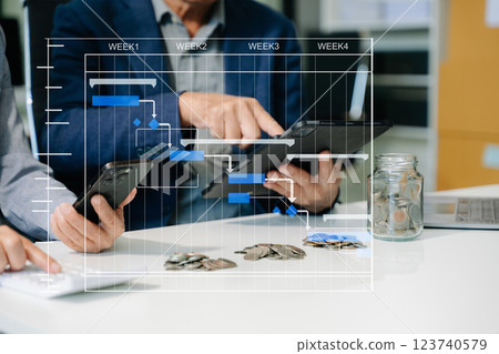 business team holding coins putting in glass with using smartphone and calculator business team holding coins putting in glass with using smartphone and calculator 123740579