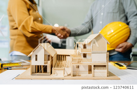 Construction team shake hands greeting start new project plan behind yellow helmet on desk in Construction team shake hands greeting start new project plan behind yellow helmet on desk in 123740611