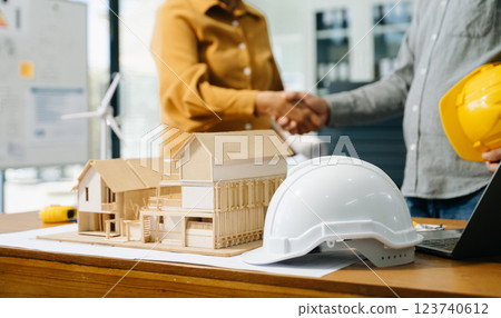 Construction team shake hands greeting start new project plan behind yellow helmet on desk in Construction team shake hands greeting start new project plan behind yellow helmet on desk in 123740612