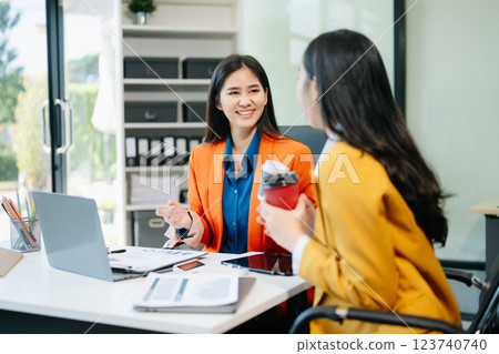 Businesswomen work and discuss their business plans. A woman employee explains 123740740