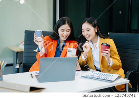 Businesswomen work and discuss their business plans. A woman employee explains 123740741