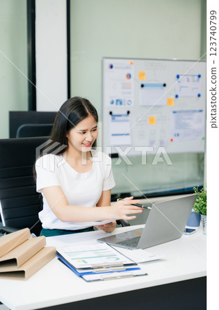 Young beautiful woman using laptop and tablet while sitting at her working place 123740799
