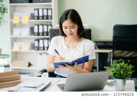 Young beautiful woman using laptop and tablet while sitting at her working place 123740828