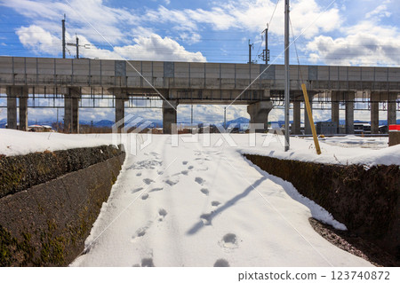 A snow-covered road and the elevated Shinkansen railway [near Kaga Onsen Station] 123740872