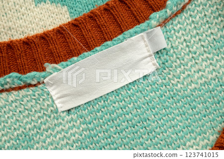 White blank laundry care clothes label on blue shirt fabric background White blank laundry care clothes label on blue shirt fabric background 123741015