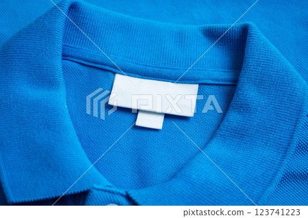 Blank white laundry care clothes label on blue shirt fabric texture background 123741223