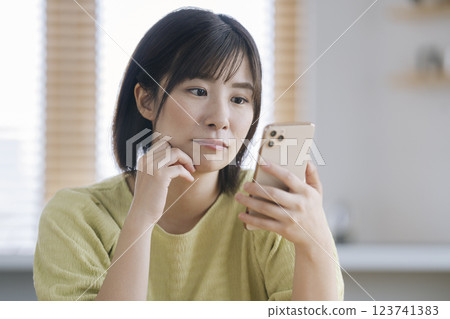 A woman in her 30s staring at her smartphone screen 123741383