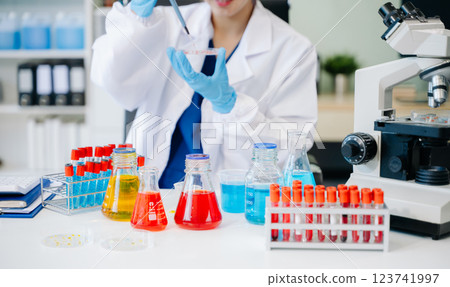 Scientists, beakers, and microscopes in cutting-edge research. Perfect for science and technology projects. 123741997