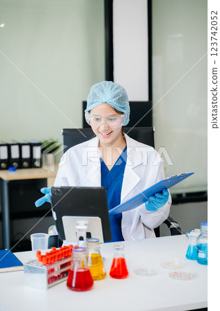 female scientist working with micro pipettes analyzing biochemical female scientist working with micro pipettes analyzing biochemical 123742052