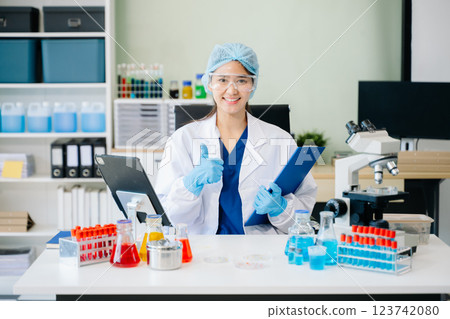 female scientist working with micro pipettes analyzing biochemical female scientist working with micro pipettes analyzing biochemical 123742080