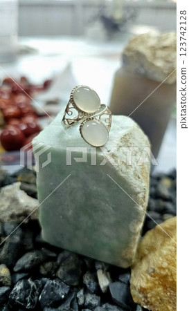 Luxurious silver ring decorated with moonstone on a natural jade base. 123742128