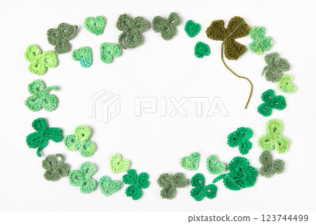 St Patrick's Day concept. Composition made of knitted green shamrocks on a gray background. Holiday sign and knitted clover leaf. Copy space, flat lay, place for text St Patrick's Day concept. Composition made of knitted green shamrocks on a gray background. Holiday sign and knitted clover leaf. Copy space, flat lay, place for text 123744499