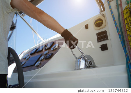 Young male captain in black gloves steering voyage boat Young male captain in black gloves steering voyage boat 123744812