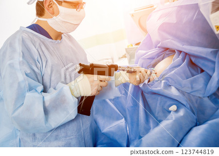 Arthroscope surgery. Orthopedic surgeons in teamwork in the operating room  123744819