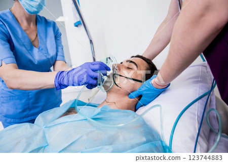 Doctors give resuscitation to a male patient in the emergency room. 123744883
