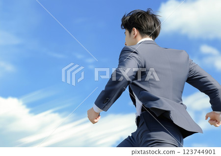 A young male businessman in a suit running 123744901