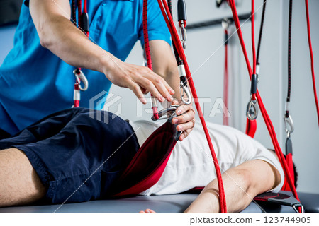 Physiotherapy. Suspension training therapy. Young man doing fitness traction 123744905