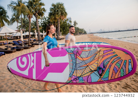 Two young surfers going into the sea with surf boards 123744932