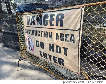 There is a noticeable sign warning of danger in front of the entrance to the construction site 123744994