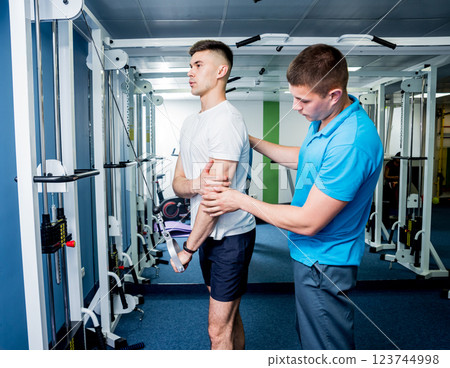 Rehabilitation therapy. Young man doing exercises on mat Rehabilitation therapy. Young man doing exercises on mat 123744998
