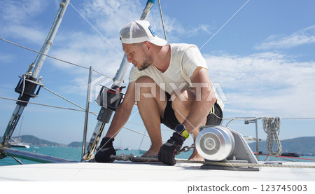 A man in a white hat is working on a voyage boat A man in a white hat is working on a voyage boat 123745003